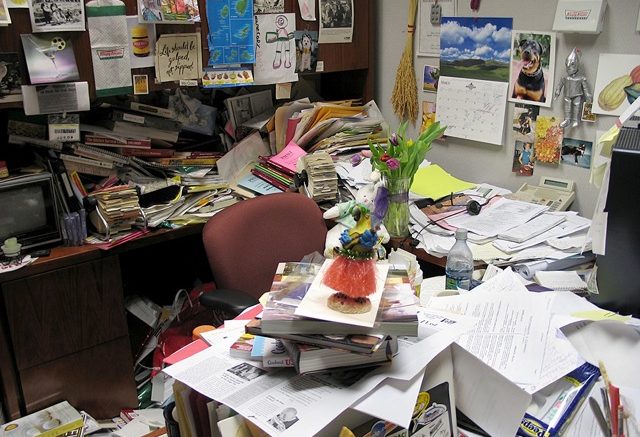 Imagem de um Ambiente de Trabalho Bagunçado, Demonstrando Como a Organização do Ambiente de Trabalho Ajuda na Saúde Mental